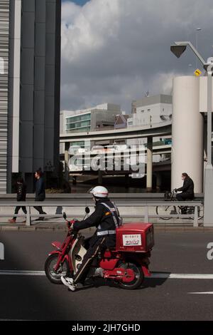 Un postier japonais sur un mobylette. Nihonbashi, Tokyo, Japon Banque D'Images