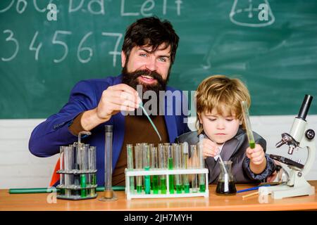 apprentissage de la chimie en laboratoire scolaire. Retour à l'école. Recherche scientifique et expériences homme enseignant avec petit garçon. Laboratoire de sciences biologiques. Père Banque D'Images