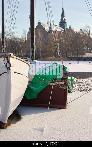 Bateaux piégés par la glace dans la baie de Djurgardsbrunnnsviken avec l'île de Djurgarden et le Nordiska Museet (musée nordique) en arrière-plan, Stockholm, Suède Banque D'Images