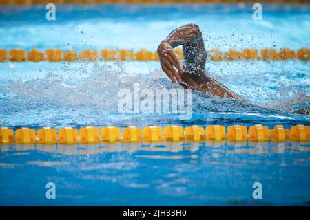 Détails avec un athlète masculin professionnel qui nage dans une piscine olympique freestyle. Banque D'Images