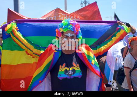 La marche de protestation TRANS Pride Brighton & Hove se fait le long du front de mer, Brighton & Hove. Un participant coloré s'arrête pour prendre une photo. 16 juillet 2022. Credit: J. Marshall / Alamy Live News Banque D'Images