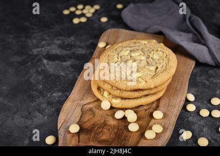 Biscuits aux pépites de chocolat blanc sur panneau de bois Banque D'Images