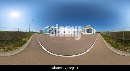 Vue panoramique à 360° de Panorama à 360 degrés entièrement sphérique sans couture en projection équirectangulaire de la zone industrielle extérieure avec des bâtiments blancs, une clôture en maille métallique et un aph