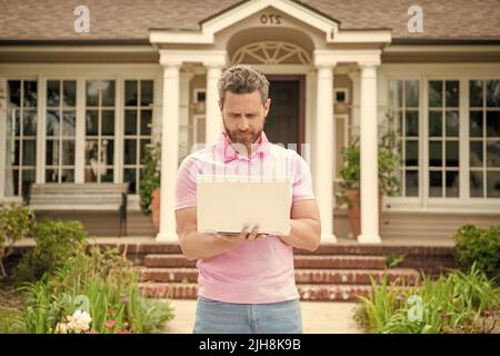 homme barbu occupé agent immobilier vendant ou louant la maison en ligne sur ordinateur, courtier Banque D'Images