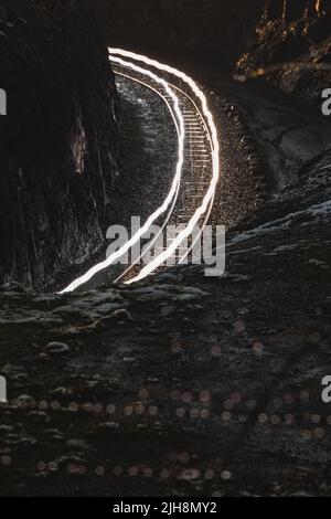 Un cliché vertical de lignes courbes de lumières vives au-dessus du chemin de fer Banque D'Images