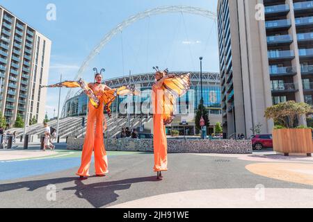 Wembley Park, Londres, Royaume-Uni. 16th juillet 2022. Stilts artistes qui arrivent pour divertir les corwds alors que l'International Busking Day revient au parc Wembley. Ce festival gratuit d'une journée a de grands noms qui partagent 9 scènes avec des artistes et des groupes populaires. L'événement du parc Wembley comprend également des espaces de détente en famille avec des ateliers de cirque, des spectacles de magie et de comédie, une routine d'évasion, de la peinture de visage et des artistes de ballons. La Journée internationale de Busking, appuyée par le maire de Londres, est présentée par Busk à Londres. Amanda Rose/Alamy Live News Banque D'Images