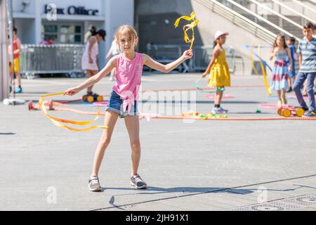 Wembley Park, Londres, Royaume-Uni. 16th juillet 2022. Les familles apprennent à l'atelier de compétences de cirque alors que la Journée internationale de Busking revient au parc Wembley. Ce festival gratuit d'une journée a de grands noms qui partagent 9 scènes avec des artistes et des groupes populaires. L'événement du parc Wembley comprend également des espaces de détente en famille avec des ateliers de cirque, des spectacles de magie et de comédie, une routine d'évasion, de la peinture de visage et des artistes de ballons. La Journée internationale de Busking, appuyée par le maire de Londres, est présentée par Busk à Londres. Amanda Rose/Alamy Live News Banque D'Images