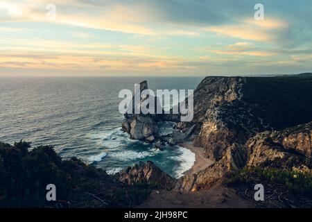 Empilement de mer rocheuse proéminente s'élevant des eaux bleues de l'Atlantique à Praia da Ursa Beach, Cabo da Roca, Sintra, Portugal Banque D'Images