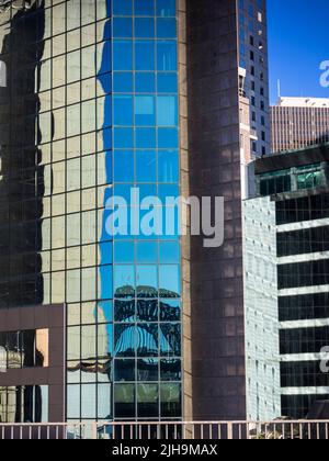 Le Sydney Harbour Bridge se reflète dans un immeuble de bureaux moderne à Circular Quay. Banque D'Images