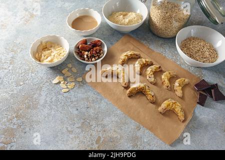 Cuisson de biscuits sains d'amande, flocons d'avoine et dattes au chocolat noir, ingrédients sur fond gris rustique, espace copie, sélection, nar Banque D'Images