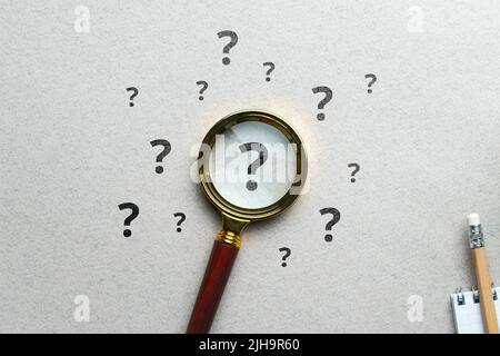 Concept de point d'interrogation ou FAQ. Affiche sous la loupe. Banque D'Images