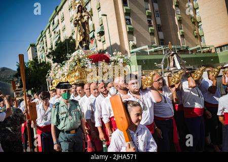 Malaga, Espagne. 17th juillet 2022. Les Pénitents de la fraternité Virgen del Carmen sont vus portant une statue de la Vierge se marient alors qu'ils marchent dans la rue pendant la procession dans le quartier 'El Palo'. Chaque année, le 16 juillet, la ville de Malaga célèbre une fête religieuse en l'honneur de la Virgen del Carmen, patronne des marins et des pêcheurs. La statue de la Vierge, portée par un groupe de croyants en costume traditionnel le long des rues, est placée sur un bateau de la plage, qui plus tard sur les voiles le long de la côte de Malaga. Crédit : SOPA Images Limited/Alamy Live News Banque D'Images