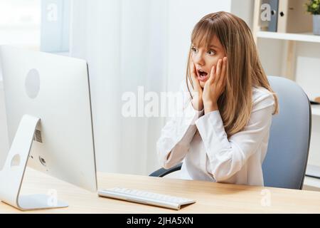 Choqué bouleversé adorable blonde femme d'affaires toucher le menton les deux mains pensant à la solution du problème dans le bureau moderne léger. L'employé travaille sur Banque D'Images