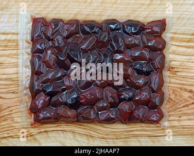 olives grecques kalmata en emballage sous vide sur panneau de bois d'olive, souvenir traditionnel à manger à la maison Banque D'Images