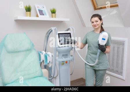 Femme médecin dans un salon de médecine tient un appareil de massage sous vide. Procédure de mise en forme du corps anti-cellulite. Appareils pour la perte de poids. Femme et médecin dans le salon de médecine. Banque D'Images