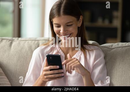 Gros plan jeune femme magnifique utilisant un smartphone à la maison Banque D'Images