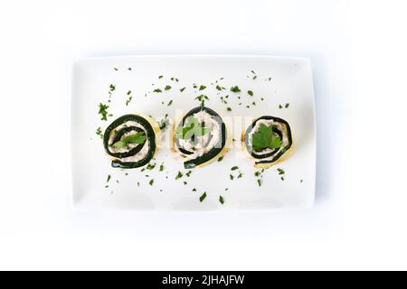 Rouleaux de courgettes grillées au thon et au fromage à la crème isolés sur fond blanc Banque D'Images