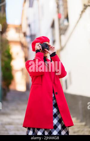 Femme souriante prenant des photos avec un appareil photo pendant les vacances Banque D'Images