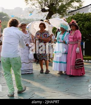 Homme prenant une photo de femmes vêtues de vêtements victoriens Bano de Olas parties Sardinero Santander Cantabria Espagne juillet 2022 Banque D'Images