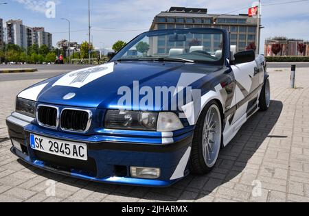 Vue de la voiture de sport BMW 3 E36 cabriolet avec jantes de sport et couvert de décalcomanies garées dans la rue. Banque D'Images