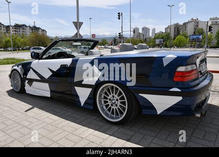 Vue de la voiture de sport BMW 3 E36 cabriolet avec jantes de sport et couvert de décalcomanies garées dans la rue. Banque D'Images