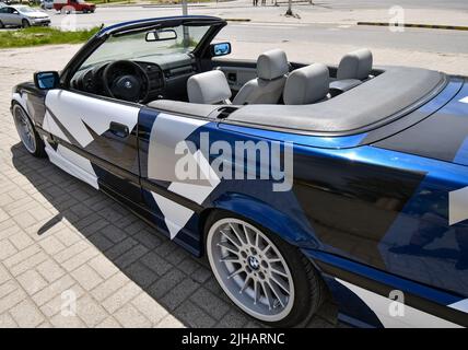 Vue de la voiture de sport BMW 3 E36 cabriolet avec jantes de sport et couvert de décalcomanies garées dans la rue. Banque D'Images