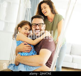 enfant fille famille heureuse mère père canapé jouer ensemble amusant fille souriante maison intérieure Banque D'Images