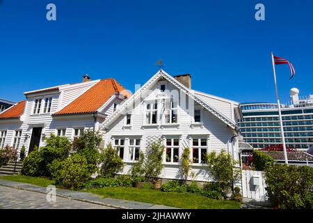 Maisons norvégiennes traditionnelles, blanches, peintes en bois sur Øvre Strandgate, Stavanger, Norvège. Le bateau de croisière P&O, MS Iona, est en arrière-plan. Banque D'Images