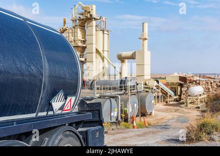 Camion-citerne chargé de bitume à haute température entrant dans une usine de fabrication d'asphalte aggloméré . Banque D'Images