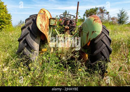 Un vieux tracteur John Deere rouillé dans un champ dans le sud de la France Banque D'Images