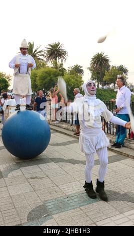 Spectacle public des artistes de cirque de Bambolea dans la rue près de Piquio Santander Cantabria Espagne avec un homme qui se balance sur une grande boule bleue et un jongleur Banque D'Images