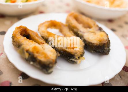 trois morceaux de carpe frite sur une assiette blanche Banque D'Images