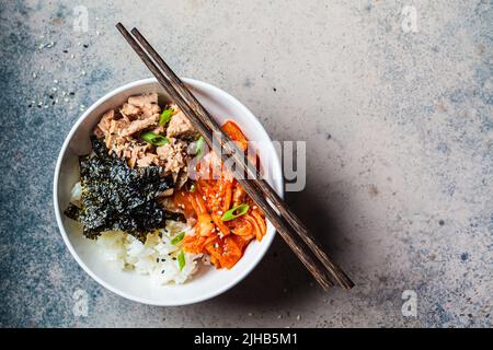 Salade de riz au thon Kimchi dans un bol blanc, vue du dessus, espace copie. Cuisine traditionnelle coréenne. Banque D'Images