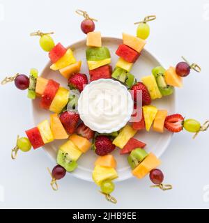 Un plateau de brochettes de fruits frais isolées sur fond blanc. Banque D'Images