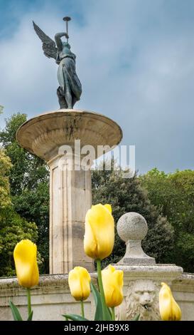 Un cliché vertical de la Fontaine de la renommée avec des tulipes dans le parc Campo Grande, Valladolid, Espagne Banque D'Images