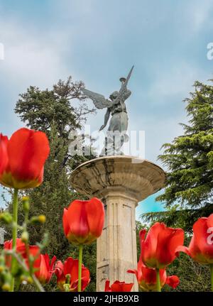 Un cliché vertical de la Fontaine de la renommée avec des tulipes dans le parc Campo Grande, Valladolid, Espagne Banque D'Images