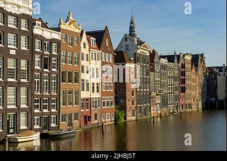 Maisons hollandaises sur le Damrak à Amsterdam au coucher du soleil Banque D'Images