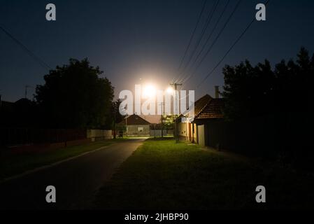 Rue de nuit dans le village, pleine lune Banque D'Images