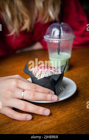 Latte au matcha glacé et gros gâteau dans un café entre les mains des femmes. Banque D'Images