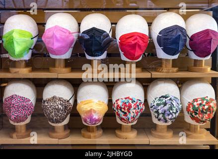 Une exposition de facemaskes tendance et colorés dans une vitrine de magasin à Rome, Italie. Banque D'Images