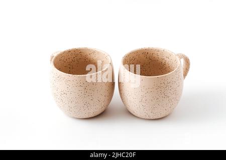 Videz les tasses en céramique beige sur un fond blanc isolé, coupées. Banque D'Images