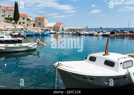 Bol, Croatie - 14 juin 2022 : petit port pittoresque avec bateaux de pêche traditionnels dans la ville Adriatique de l'île de bol sur Brac, célèbre destination touristique Banque D'Images