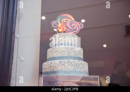 Un gâteau à trois niveaux dans un magasin de gâteaux, avec des sucettes au sommet Banque D'Images