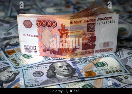 Monnaie russe rouble vs dollar américain, le billet de banque rouble est au dessus de la pile de billets en dollars. Concept de sanctions, monnaie, victoire du rouble, économie de la Russie A. Banque D'Images