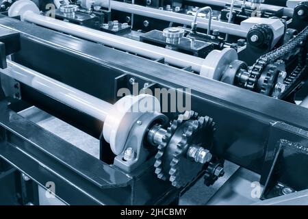 L'arbre d'entraînement de la chaîne d'engrenages de la courroie du convoyeur se trouve sur la chaîne de production. Chaîne de distribution du véhicule, tendeurs dans le moteur. Chaîne à rouleaux industrielle, technologie. L'équipe va Banque D'Images