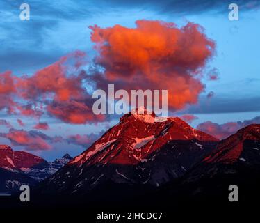 Des nuages aux couleurs chaudes flottent sur une montagne rocheuse du Montana Banque D'Images