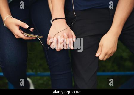 Il n'y a pas de place ID plutôt que d'être ici. Un couple méconnaissable écoutant de la musique ensemble à l'extérieur. Banque D'Images