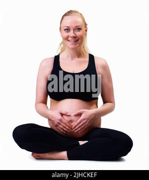 Femme enceinte avec les mains formant le coeur contre le blanc. Amour et nouvelle vie - femme enceinte avec les mains formant le coeur contre blanc Banque D'Images