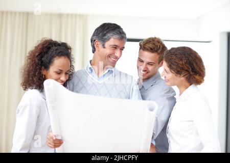 Un groupe de quatre architectes qui s'intéressent à la conception de leur groupe. Banque D'Images