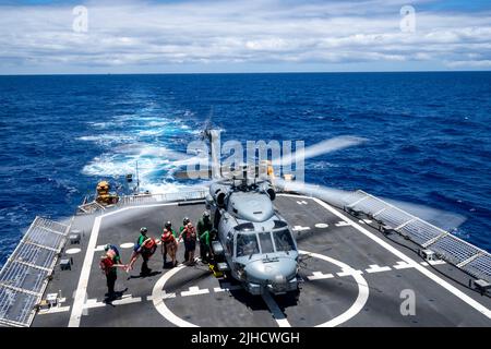 OCÉAN PACIFIQUE (15 juillet 2022) les marins de la Marine américaine transfèrent des survivants simulés du couteau de classe Legend USCGC Midgett (WMSL 757) à un hélicoptère Seahawk MH-60R de la Marine qui sera transporté vers le destroyer JS Izumo (DDH-183) de la Force maritime d'autodéfense du Japon lors d'un effort de sauvetage de masse au bord du Pacifique (RIMPAC) 2022. Vingt-six nations, 38 navires, quatre sous-marins, plus de 170 avions et 25 000 membres du personnel participent au programme RIMPAC de 29 juin au 4 août dans les îles hawaïennes et dans le sud de la Californie. Le plus grand exercice maritime international au monde, RIMPAC prov Banque D'Images